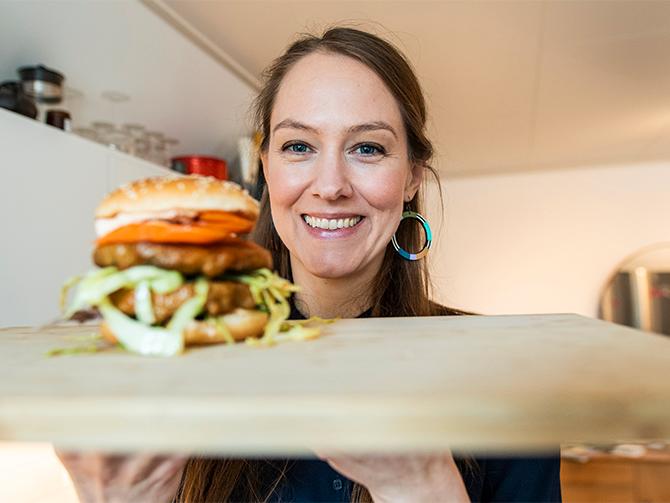 Pia Qvarnström visar upp en smaskig hamburgare gjord på Bärta. ”Vi får en del frågor om vad man kan göra med ”pappret” – när det är själva produkten, säger hon.