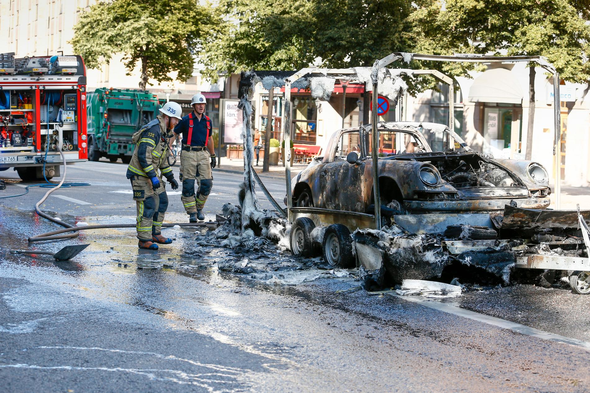 Rök syntes över centrala Stockholm vid en kraftig brand i en Porsche på ett släp.