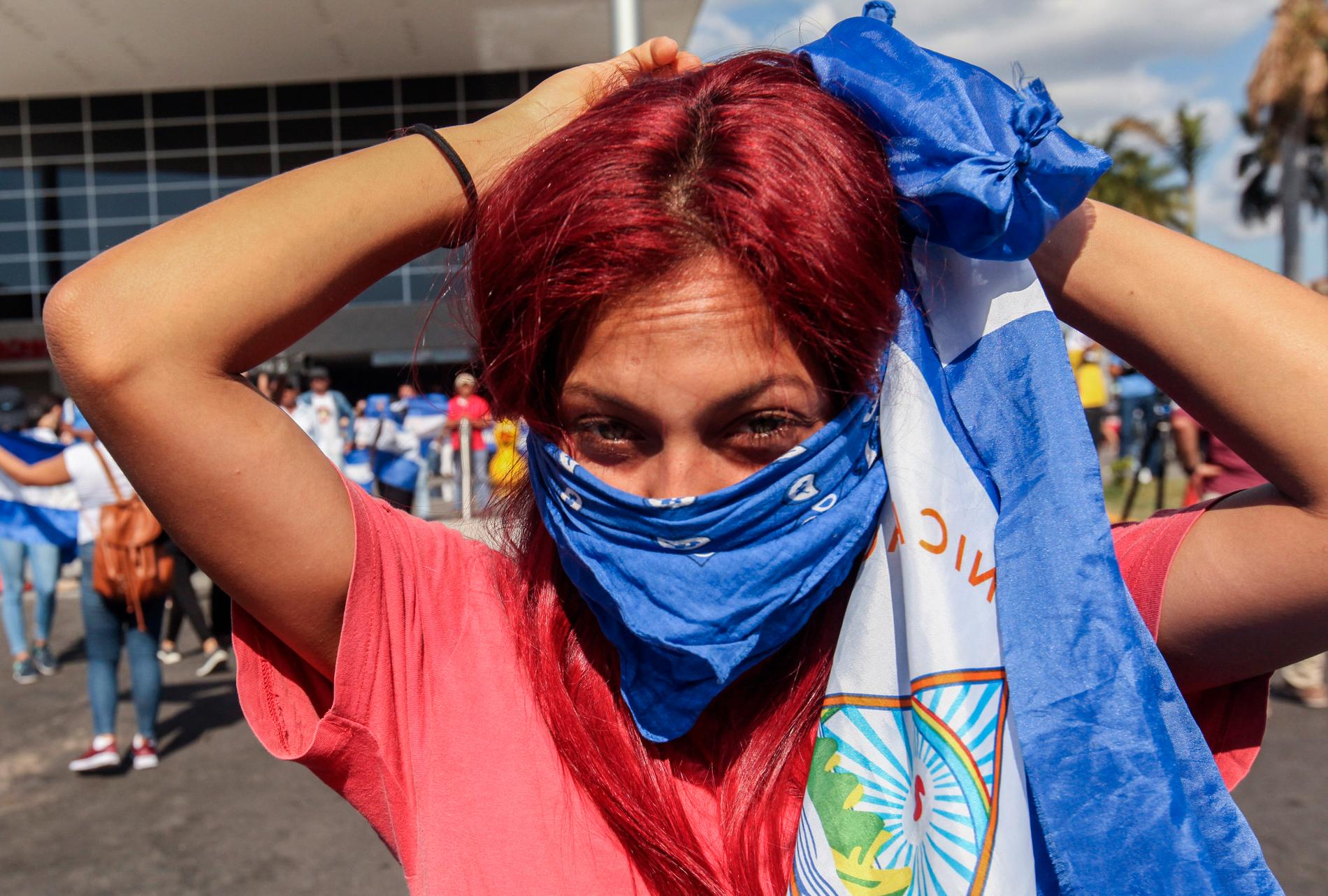 En demonstrant maskerar sig under en protest där frisläppandet av fångar utkrävdes för en månad sedan.