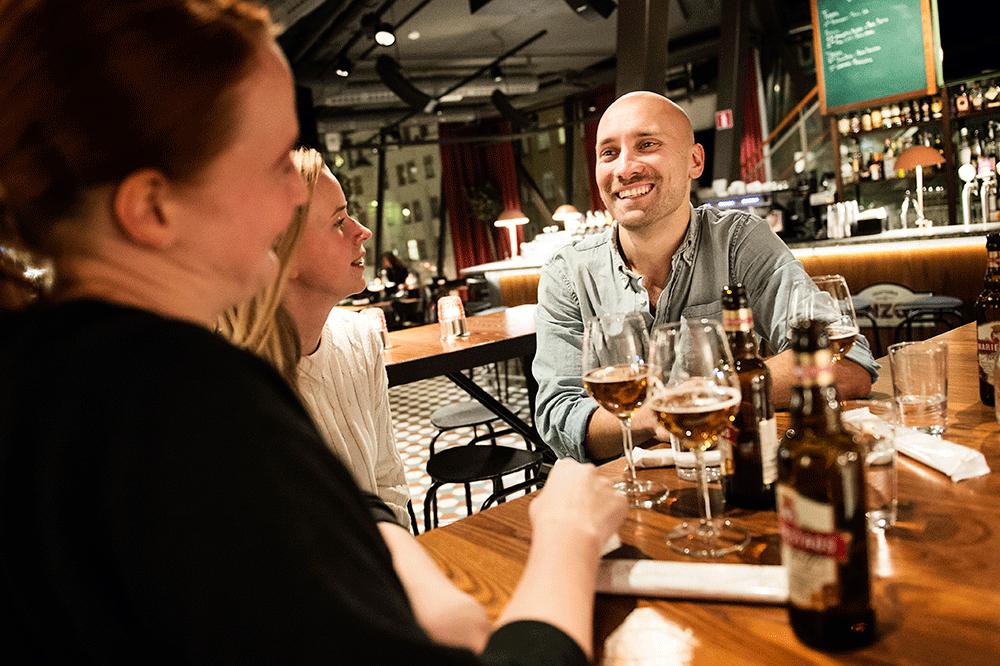 Martin Segerlund, kompisen Madelaine Ljungholm och Aftonbladets reporter Tove Björnlundh diskuterar spartips över av en alkoholfri öl på Hornhuset i Hornstull i Stockholm.