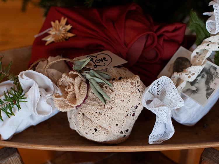 Julklapparna är vackert inslagna med loppisfyndade dukar och dekorerade med växter från trädgården och loppisfyndat halmpynt. 