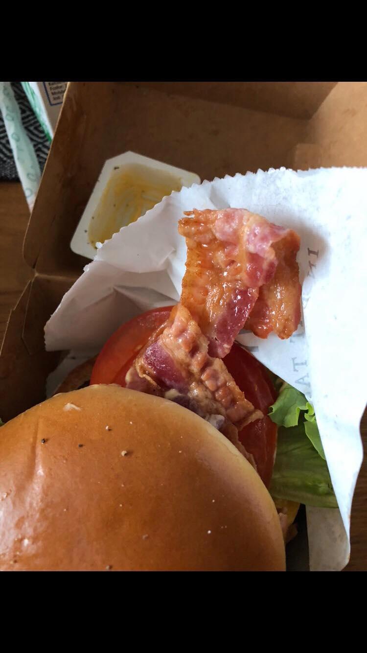 Elin fick bacon i sin vegetariska burgare. 