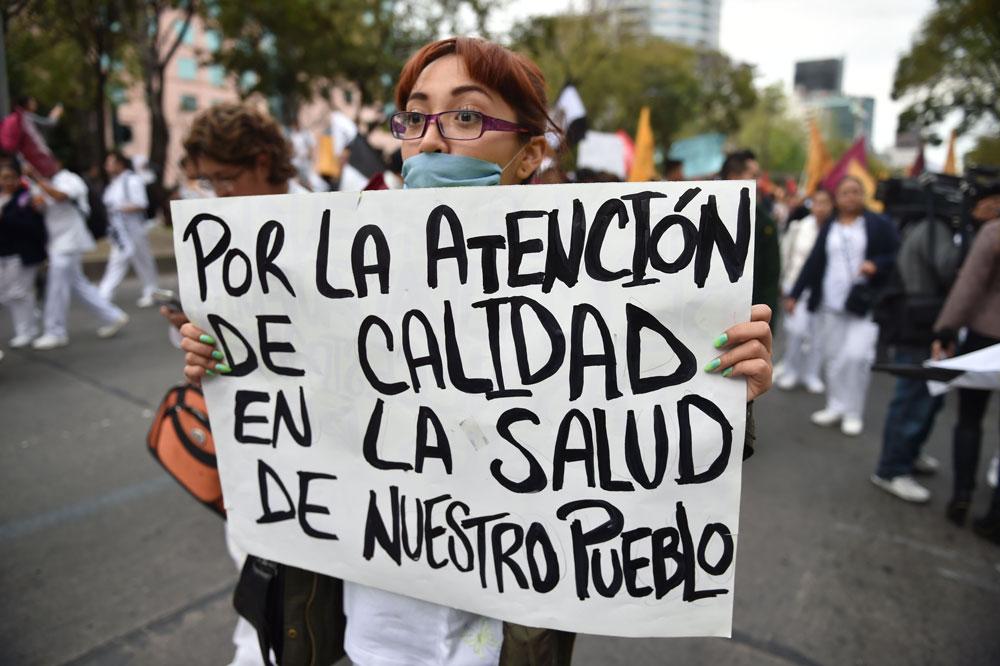 En sköterska i Mexiko City protesterar mot bättre arbetsförhållanden och rättvisa för de 43 studenter som saknas från delstaten Guerrero sedan ifjol. Det är samma delstat där man nu har hittat ett flertal halshuggna kroppar.
