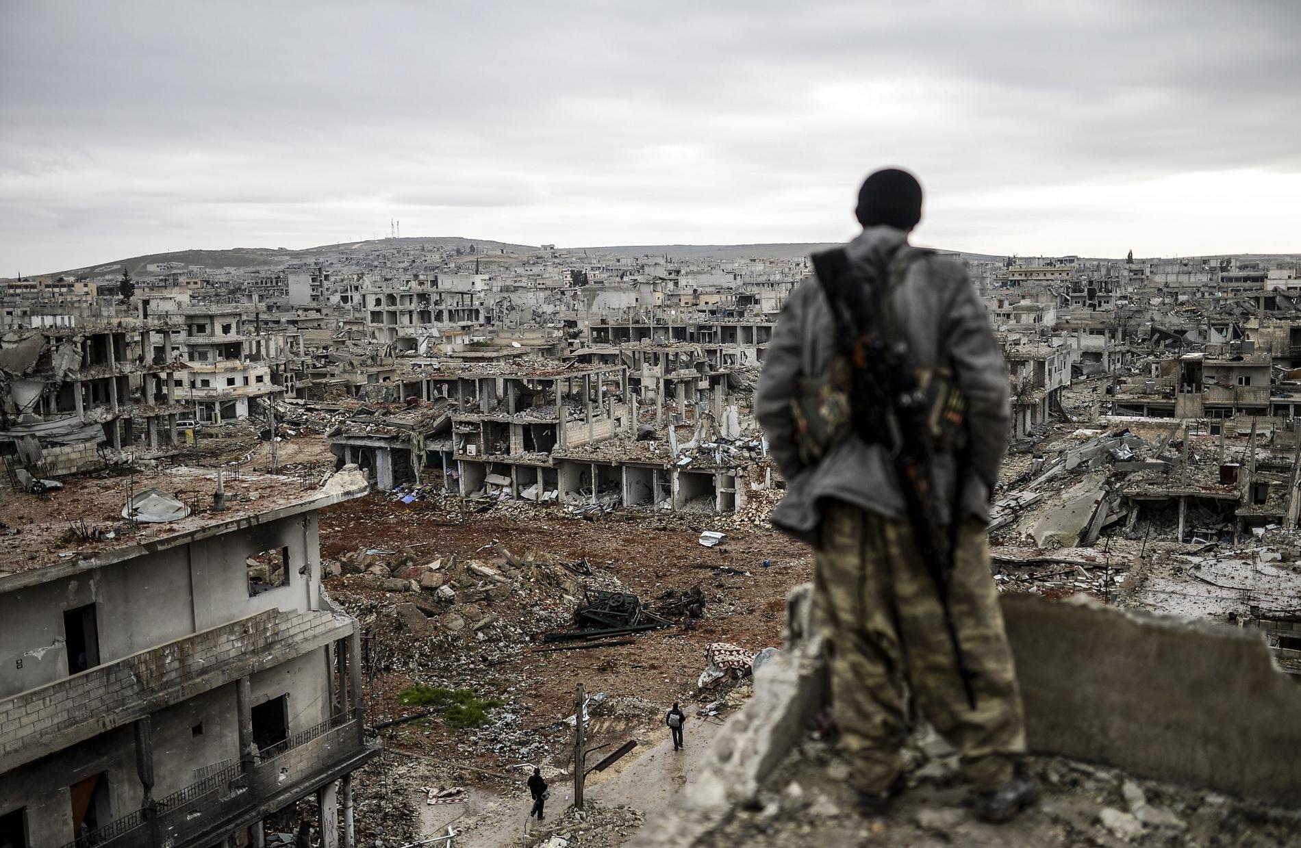 26 januari: Kurdiske soldaten Musa, 25, blickar ut över staden Kobane, nära turkiska gränsen som förstörts efter attacker från IS – och nu återtagits.