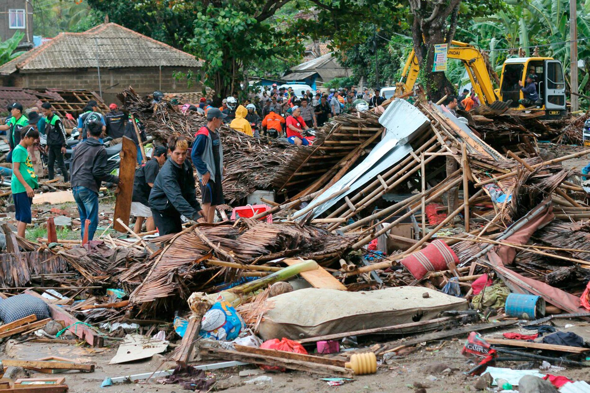 Invånare inspekterar ett hus som ödelades av tsunamin.