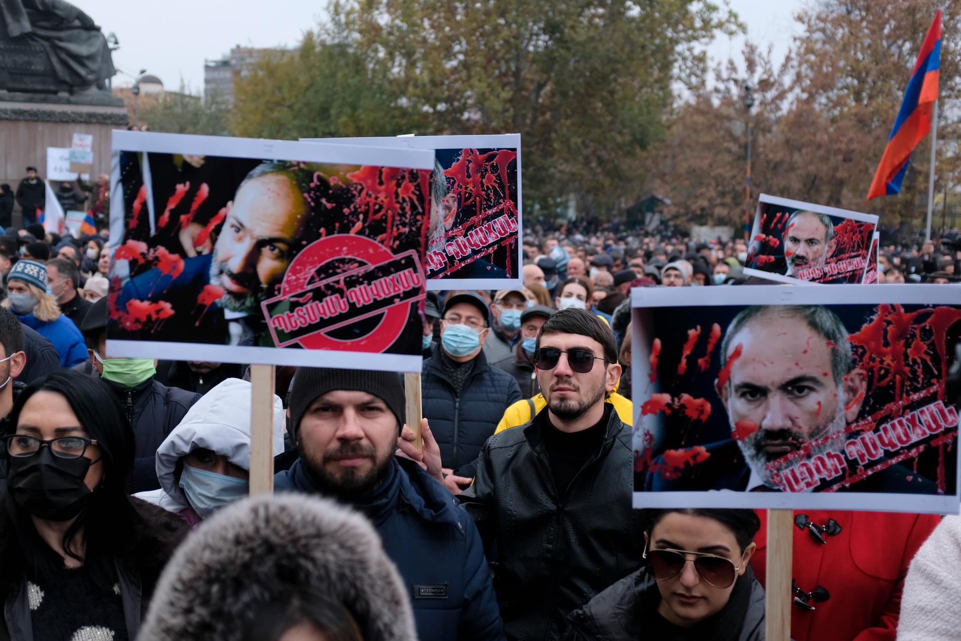 Demonstranter i Armeniens huvudstad Jerevan bär plakat där premiärminister Nikol Pasjinian framställs som blodbesudlad.
