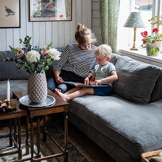 I soffan sitter Petra och äldsta sonen Olof. Vasen på soffbordet kommer från en lokal inredningsbutik.