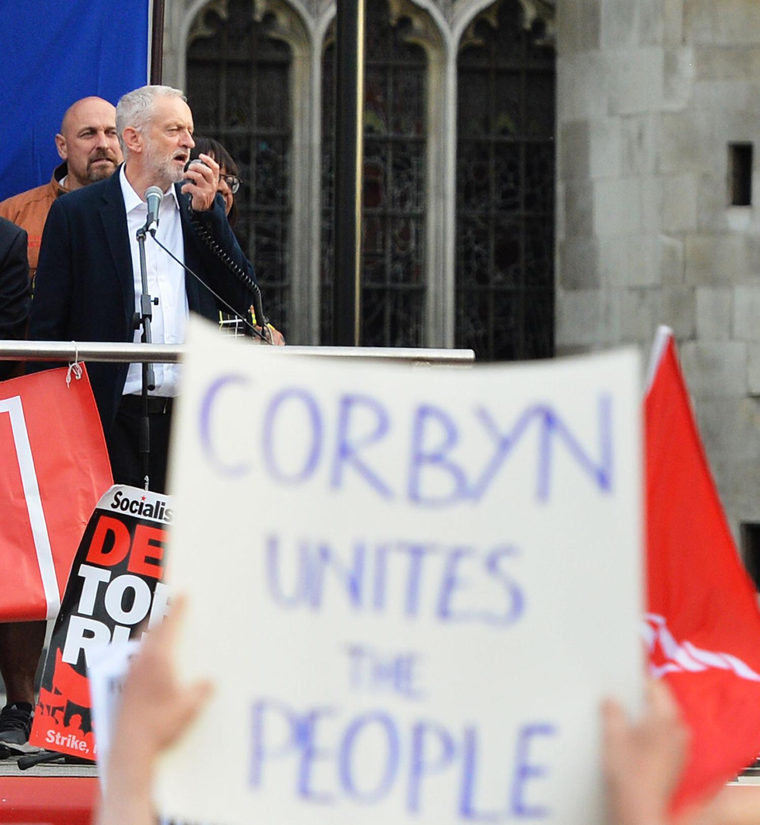 En handskriven skylt med texten "Corbyn förenar folket" hölls högt när Corbyn talade den 27 juni. Foto: AP