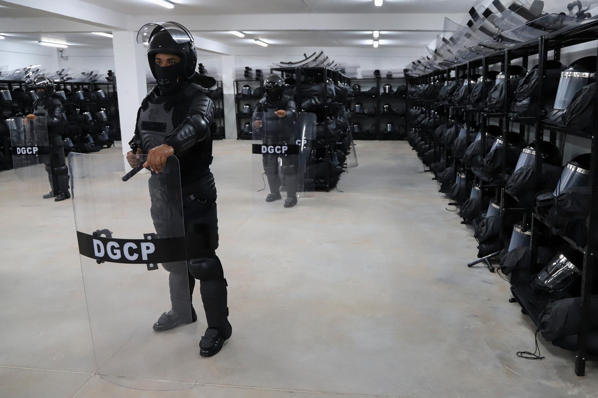 Poliser visar upp vapen och utrustning i för pressen, vid Terrorism Confinement Cente i Tecoluca, El Salvador. 