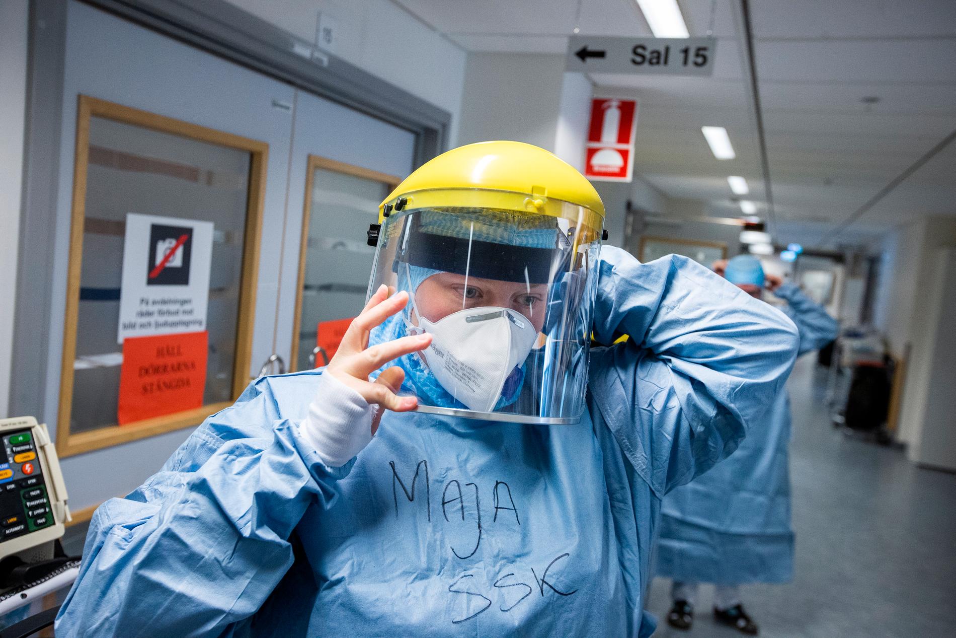 När all skyddsutrustning är på plats trär sjuksköterskan till slut på visiret innan hon går in till patienterna i salen.