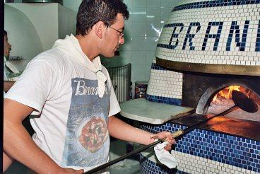 Massimo Errico skickar in pizzorna i den vackra vedugnen på Antica pizzeria Brandi.