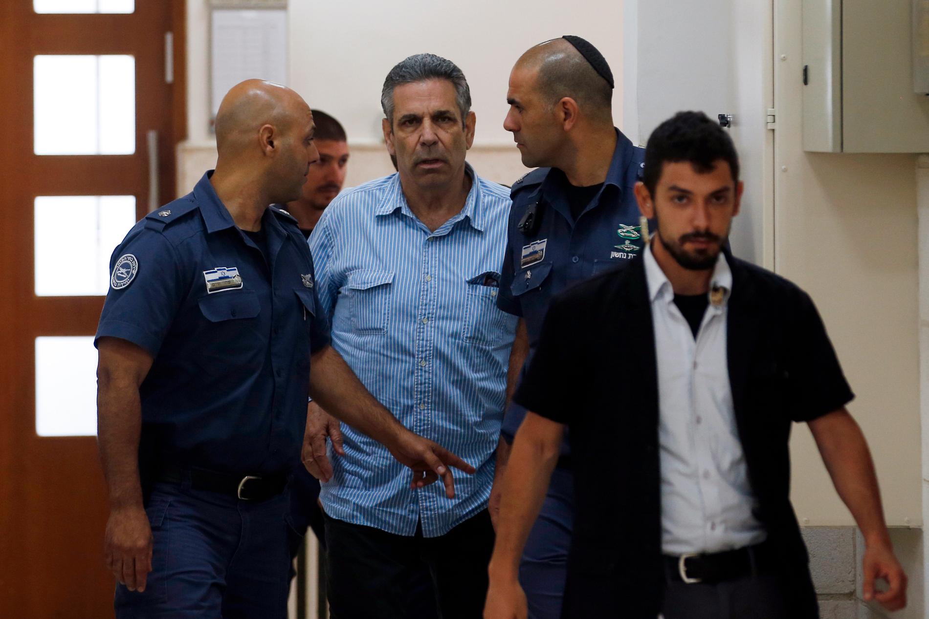 Den tidigare israeliske ministern Gonen Segev förs in av vakter till en domstol i Jerusalem i juli.