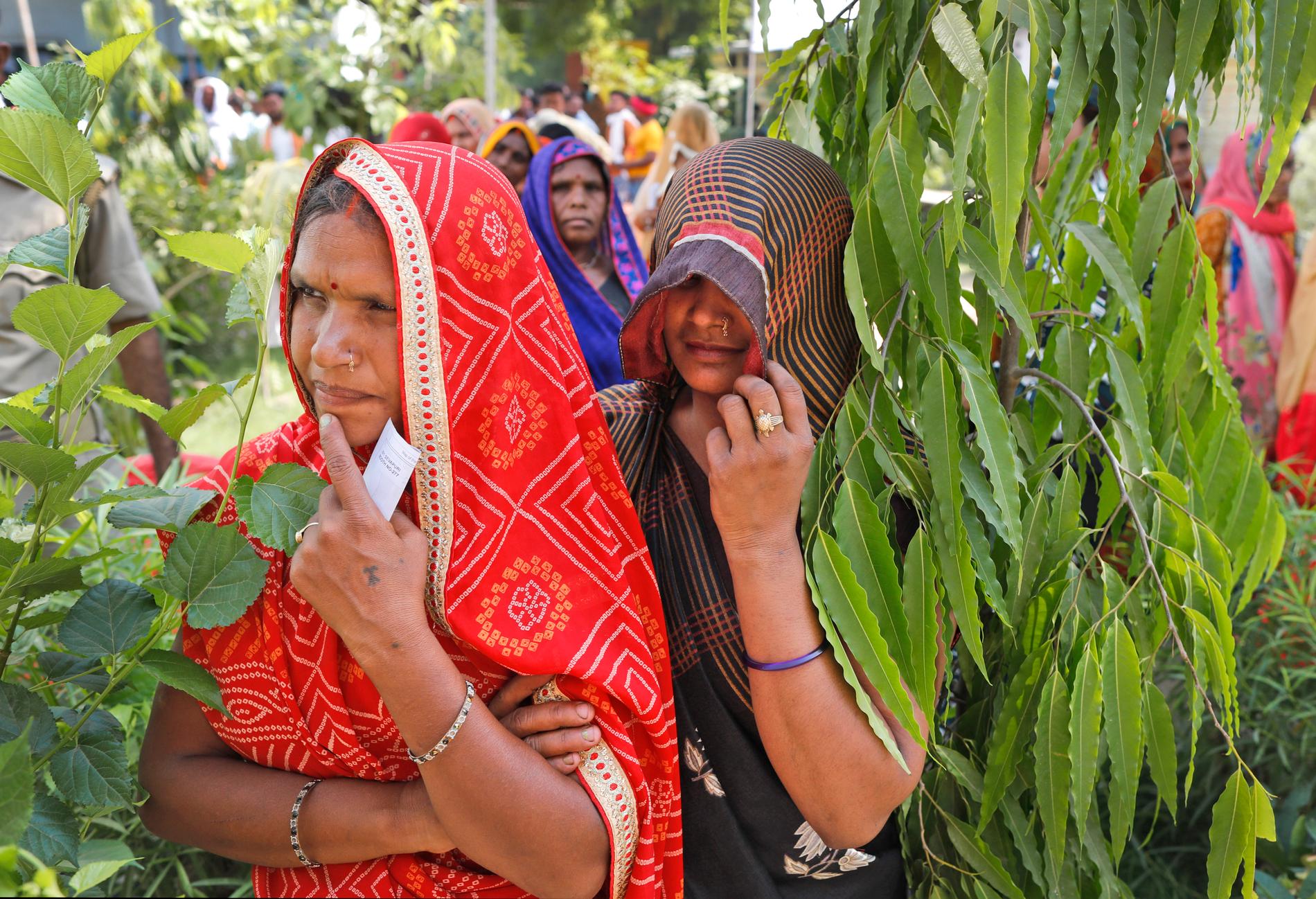 Indiska kvinnor står i kö för att rösta i Varanasi på det utdragna parlamentsvalets sista dag.