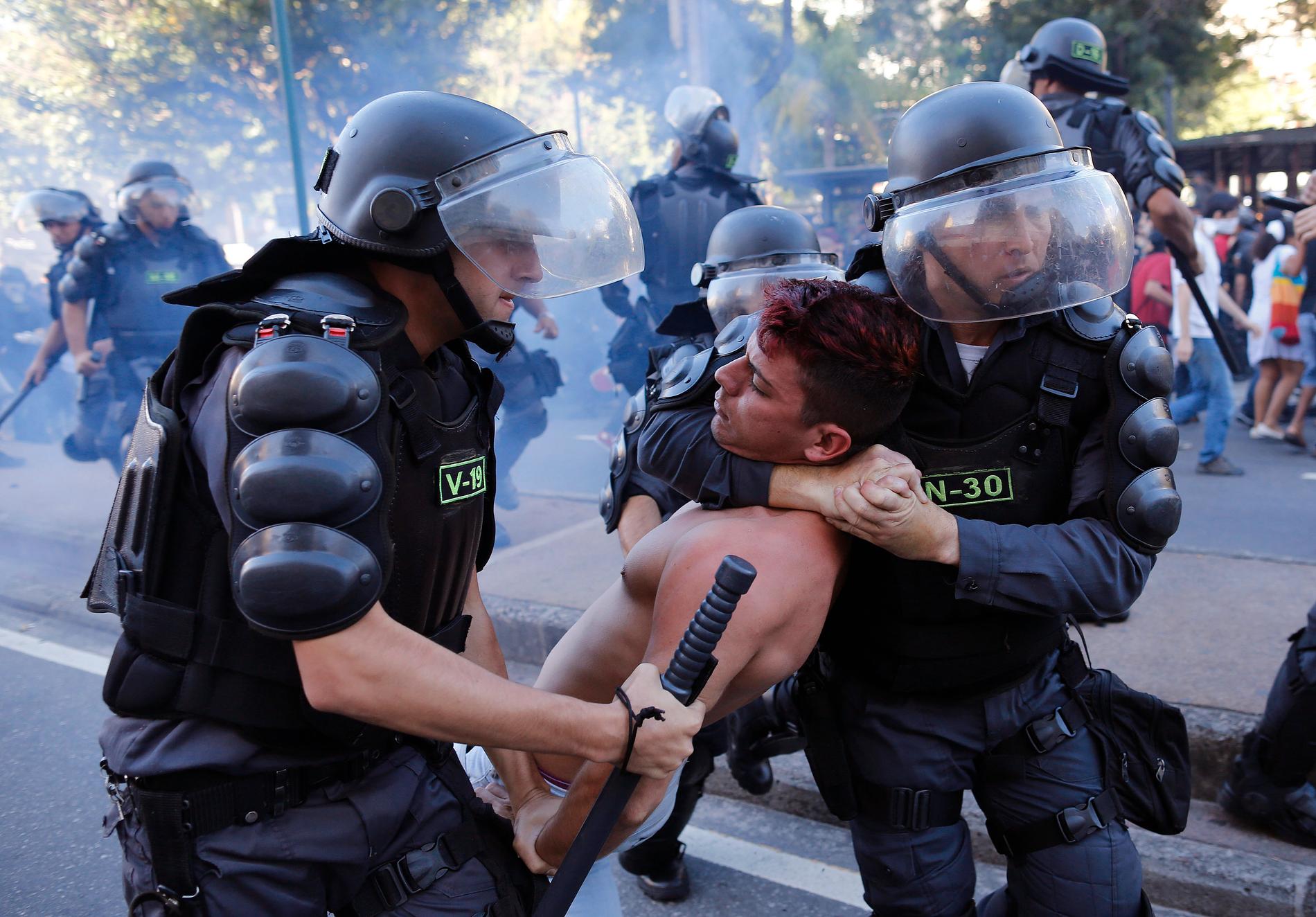 Polisen tar han om en demonstrant i samband med demonstrationer mot fotbolls VM som hölls 2014.