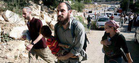 Tar över En judisk familj på väg att ta över ett hus där de palestinska ägarna just drivits bort.