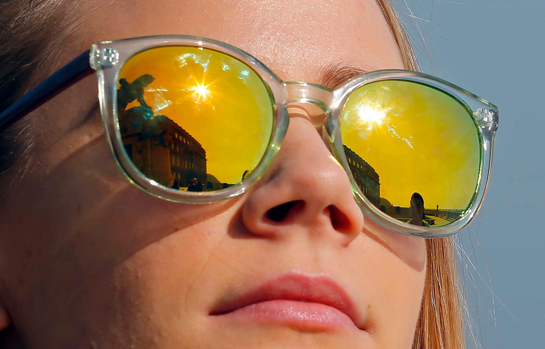 Solens reflexer i ett par glasögon på en kvinna i Bukarest.