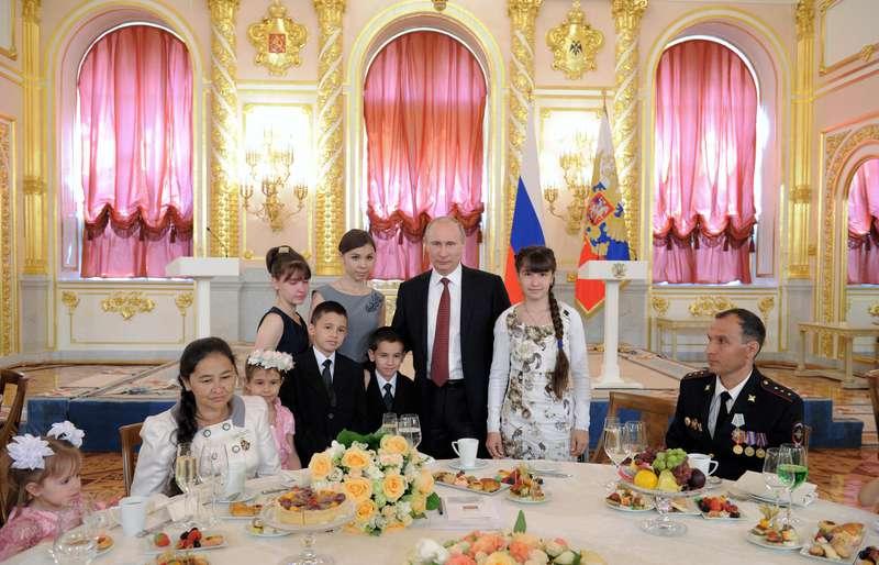PUTINS FAMILJEDRÖM. Rysslands president Vladimir Putin tillsammans med sjubarnsfamiljen Morokov vid en ceremoni i Kreml där famijer med många barn belönades av staten.