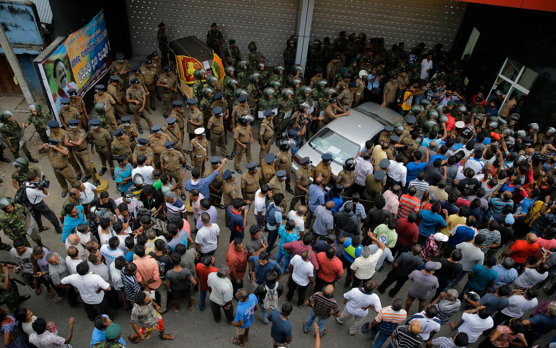 Säkerhetsstyrkor utanför Arjuna Ranatungas kontor efter dödsskjutningen i går.
