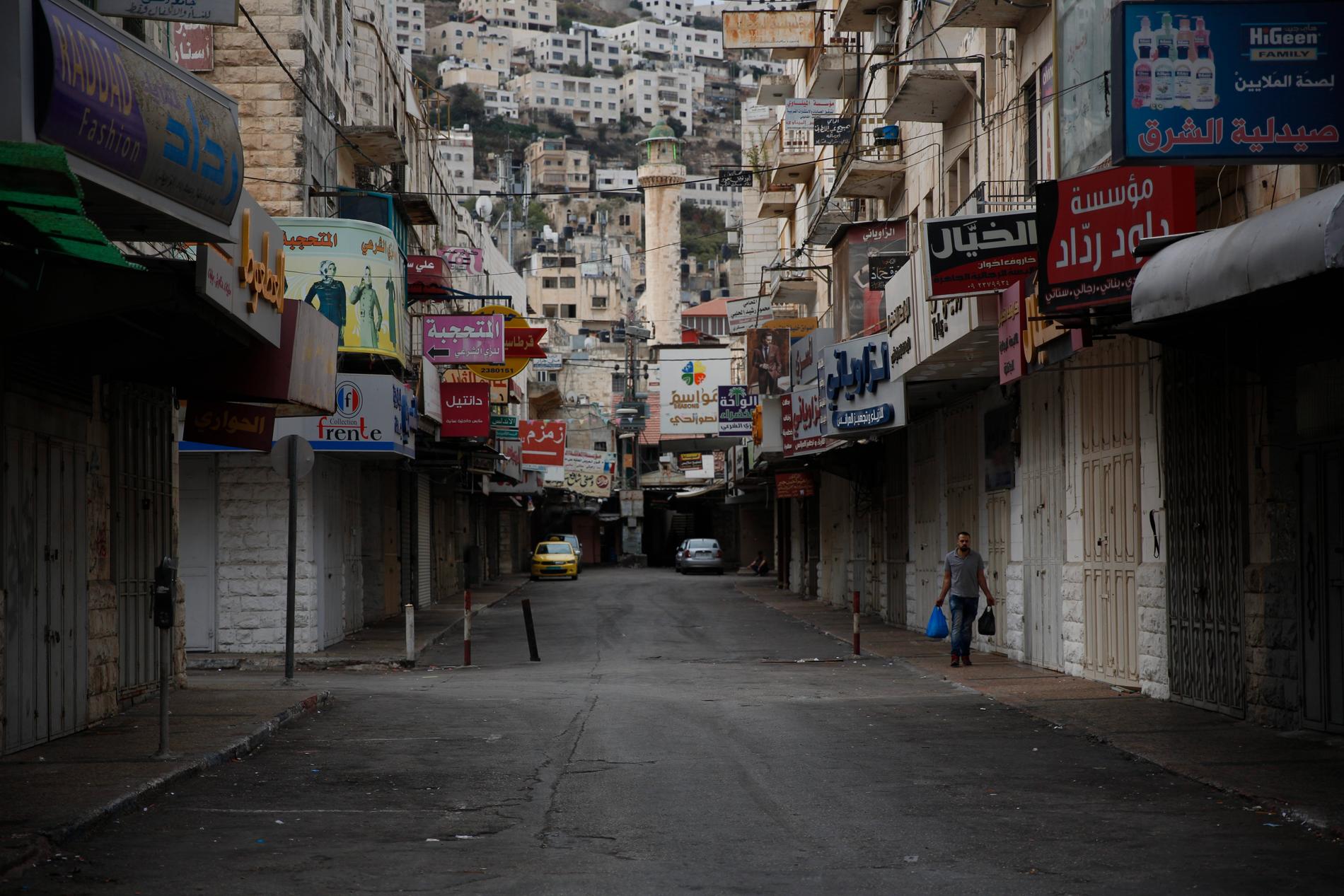 En palestinsk man framför stängda affärer i Nablus på Västbanken.