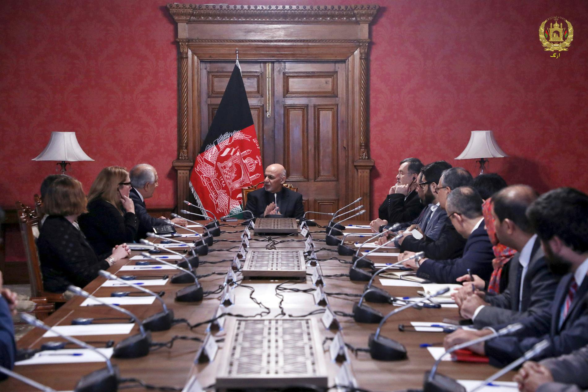 Afghanistans president Ashraf Ghani (i mitten) talar till Zalmay Khalilzad (tredje från vänster), USA:s särskilda sändebud i fredssamtalen.