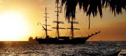 Ett segelfartyg i solnegången – en klassisk bild av Karibien.