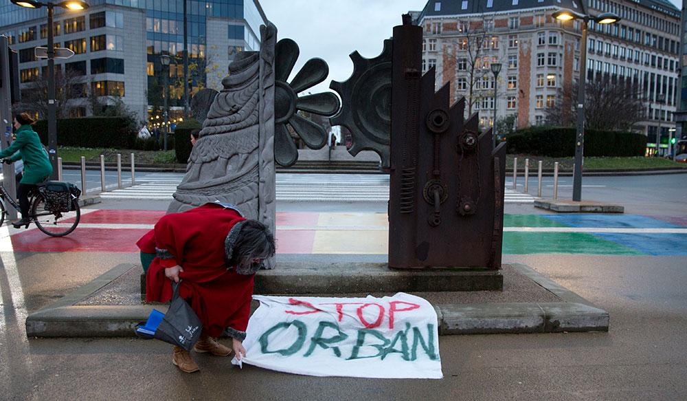 En kvinna placerar en skylt med budskapet ”Stoppa Orban” utanför EU-parlamentet i Bryssel.