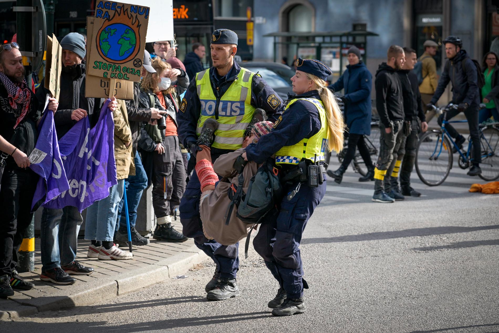 Polis bär bort aktivister från Extinction Rebellion som blockerar trafiken i gatukorsningen Sveavägen-Kungsgatan in en aktion för klimatet under namnet "Fossilupproret".