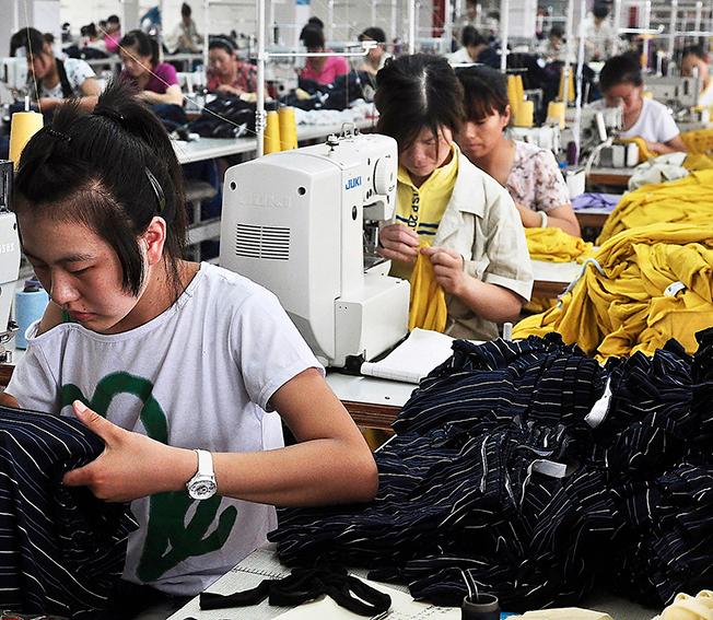 tuffa villkor Arbetare på en kinesisk textilfabrik syr kläder av bambu.