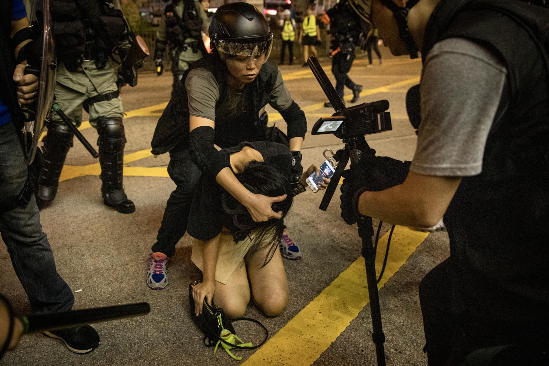 En demonstrant arresteras av polis utanför Mong Kok polisstation.