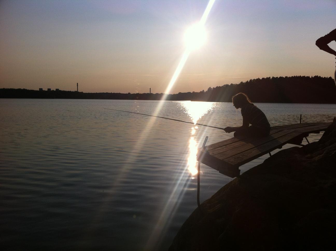 Sommarbild från kvällsfiske i Drevviken, Stockholm. Ella, 11, fiskar.