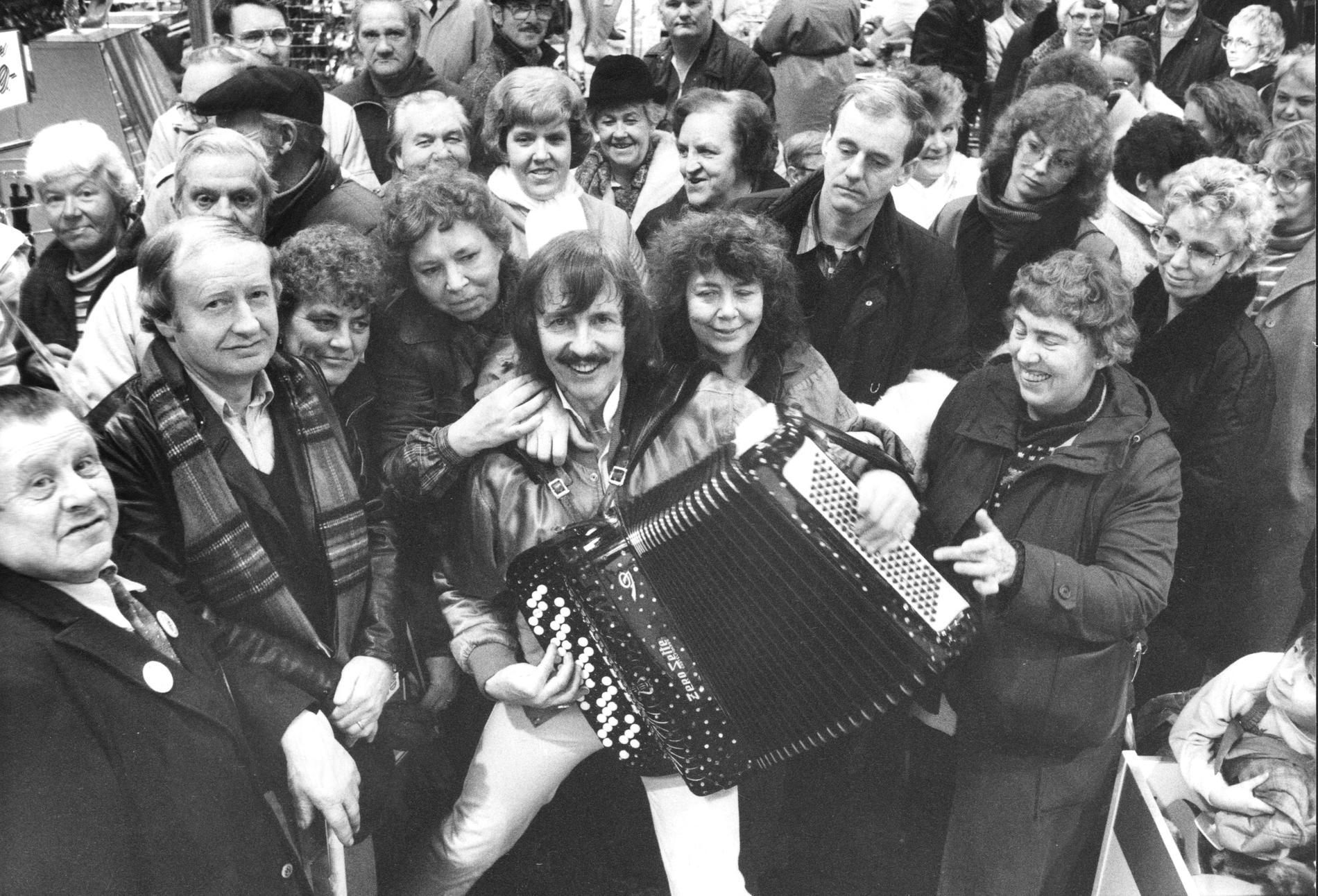 Roland Cedermark 1985 omgiven av fans under ett uppträdande i en butik.