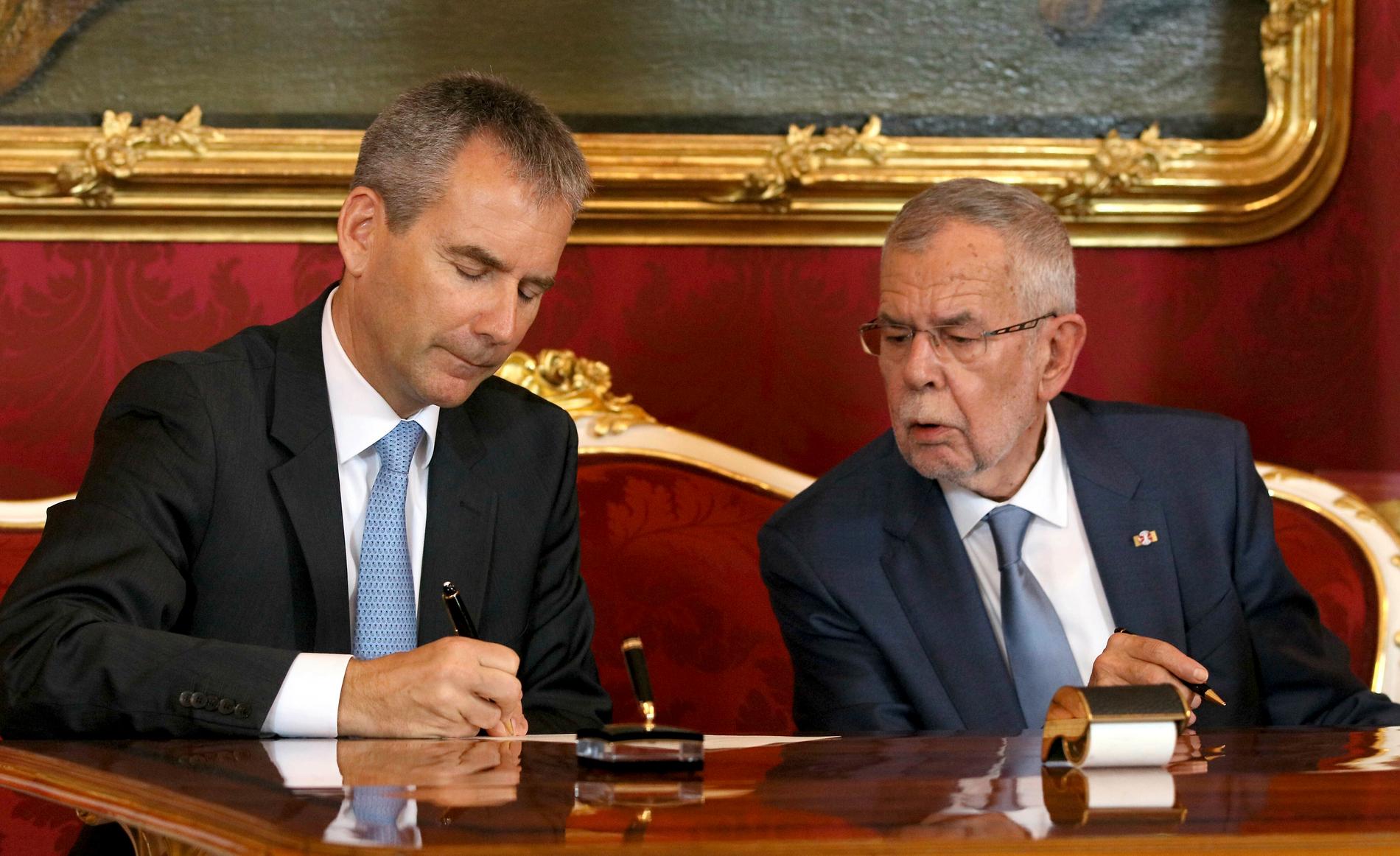 Österrikes tillförordnade förbundskansler Hartwig Löger (till vänster) med förbundspresident Alexander Van der Bellen under insvärningsceremonin i Hofburg i Wien.