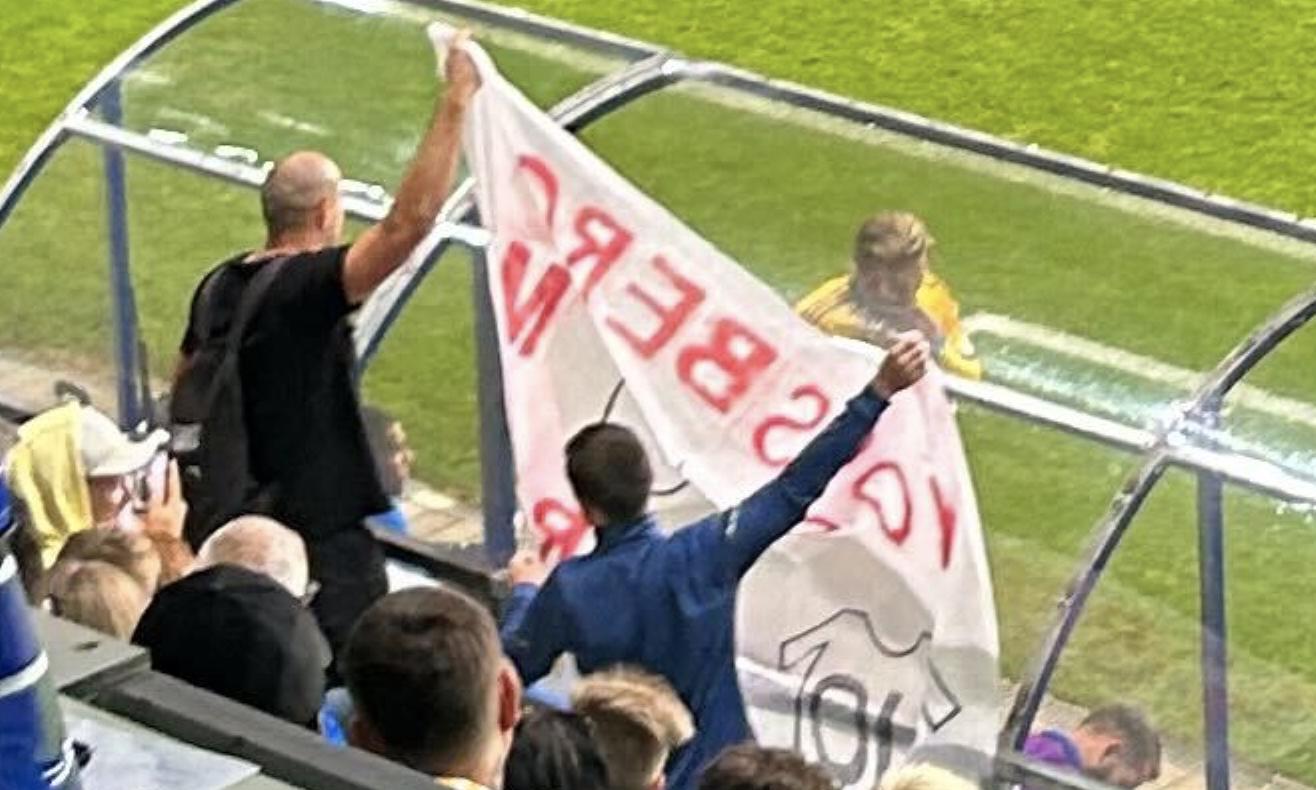 Två supportrar med banderollen.
