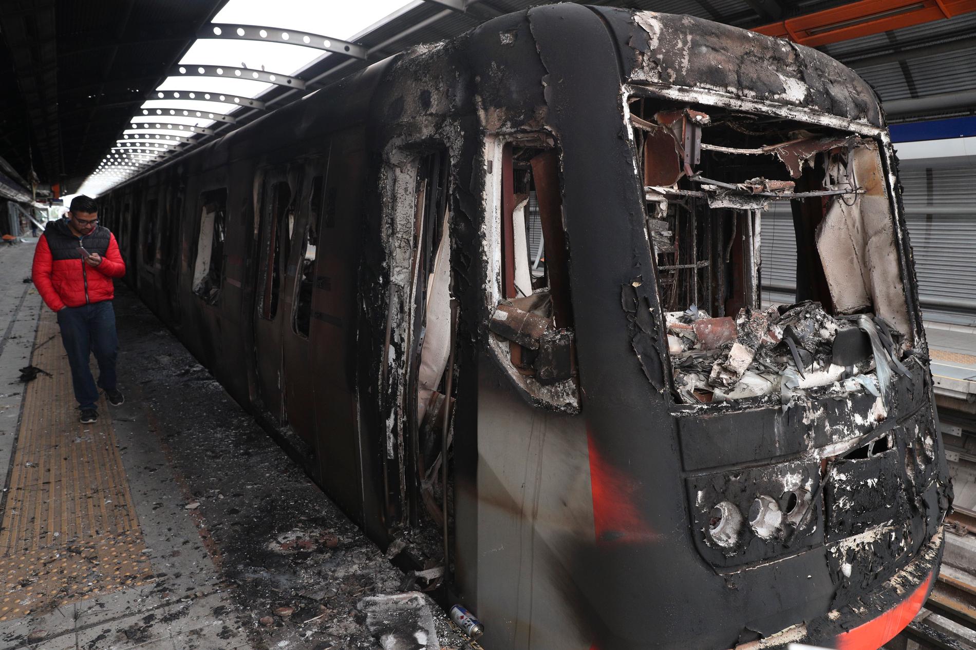 Flera bränder har anlagts i samband med protesterna i Santiago. Här är en tunnelbanevagn som bränts.