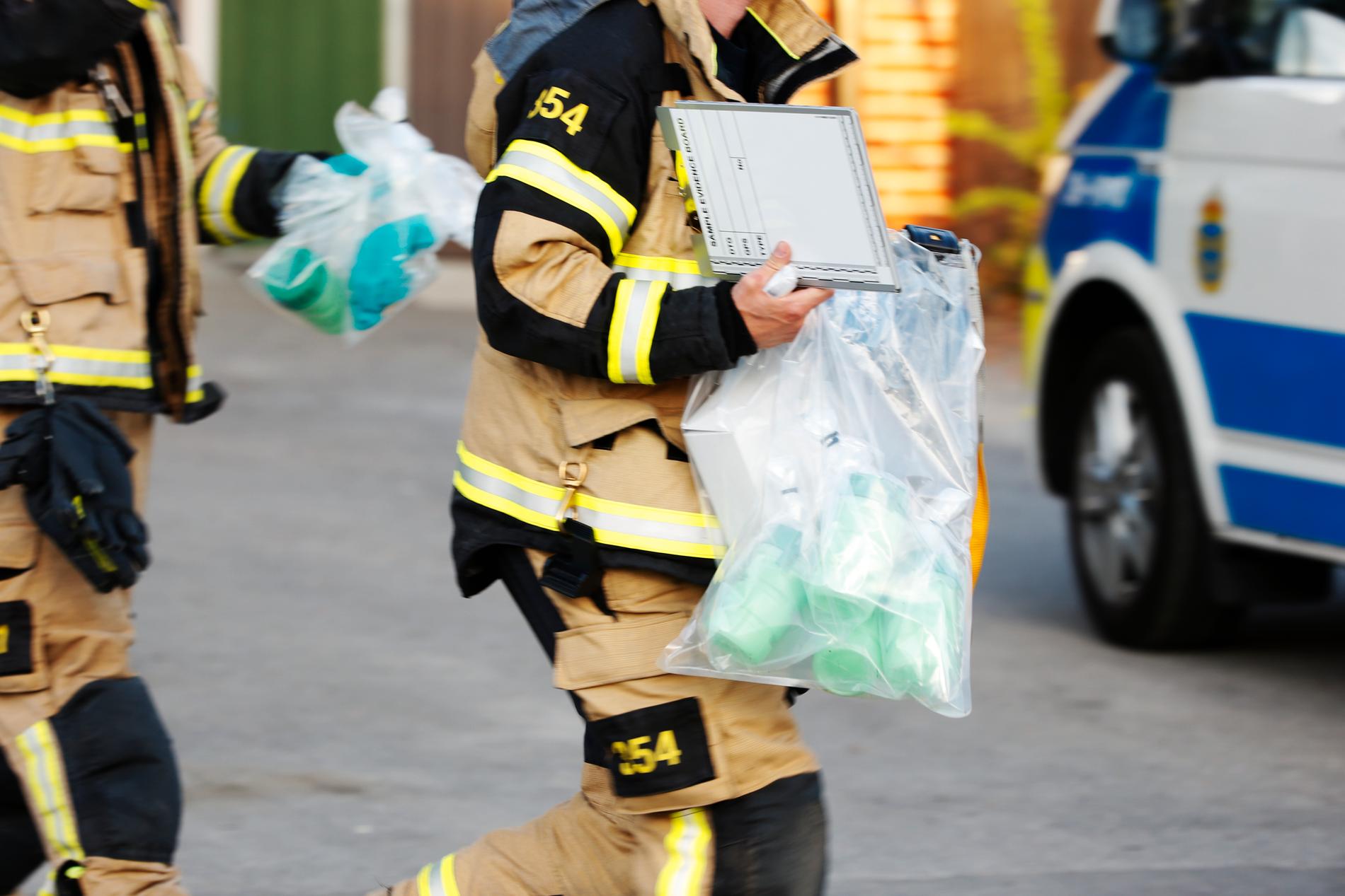 Personal från räddningstjänsten bär bort giftampullerna som hittades på en förskolegård i Gustavsberg på måndagen.