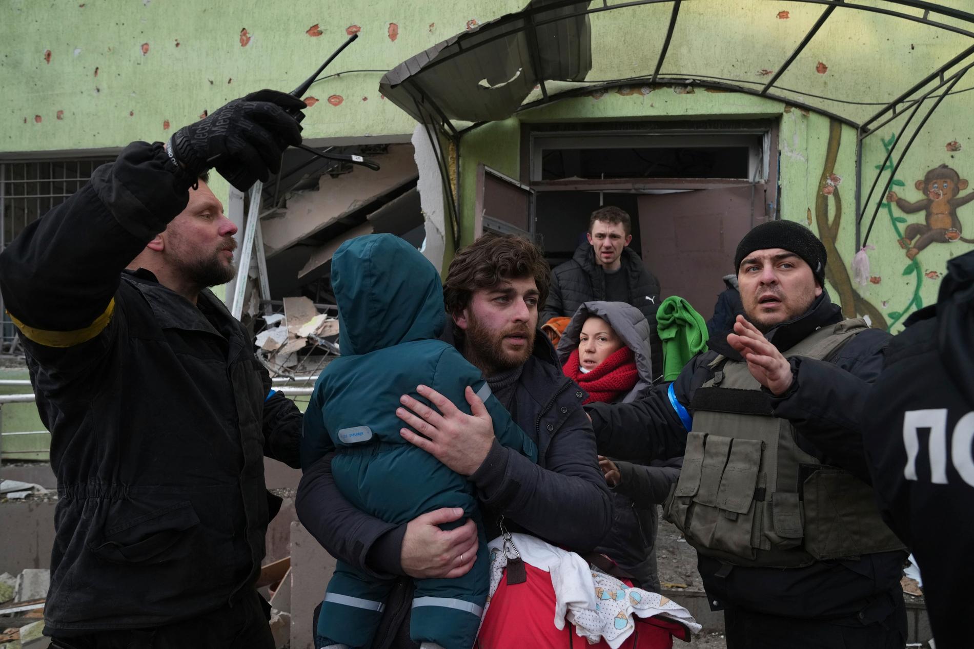 På onsdagseftermiddagen bombade rysk militär ett barnsjukhus i den belägrade ukrainska hamnstaden Mariupol. Flera avdelningar, bland annat förlossningsvavdelningen, totalförstördes och barn och kvinnor begravdes under rasmassorna. Här bär en man bär bort sitt barn från det demolerade sjukhuset.