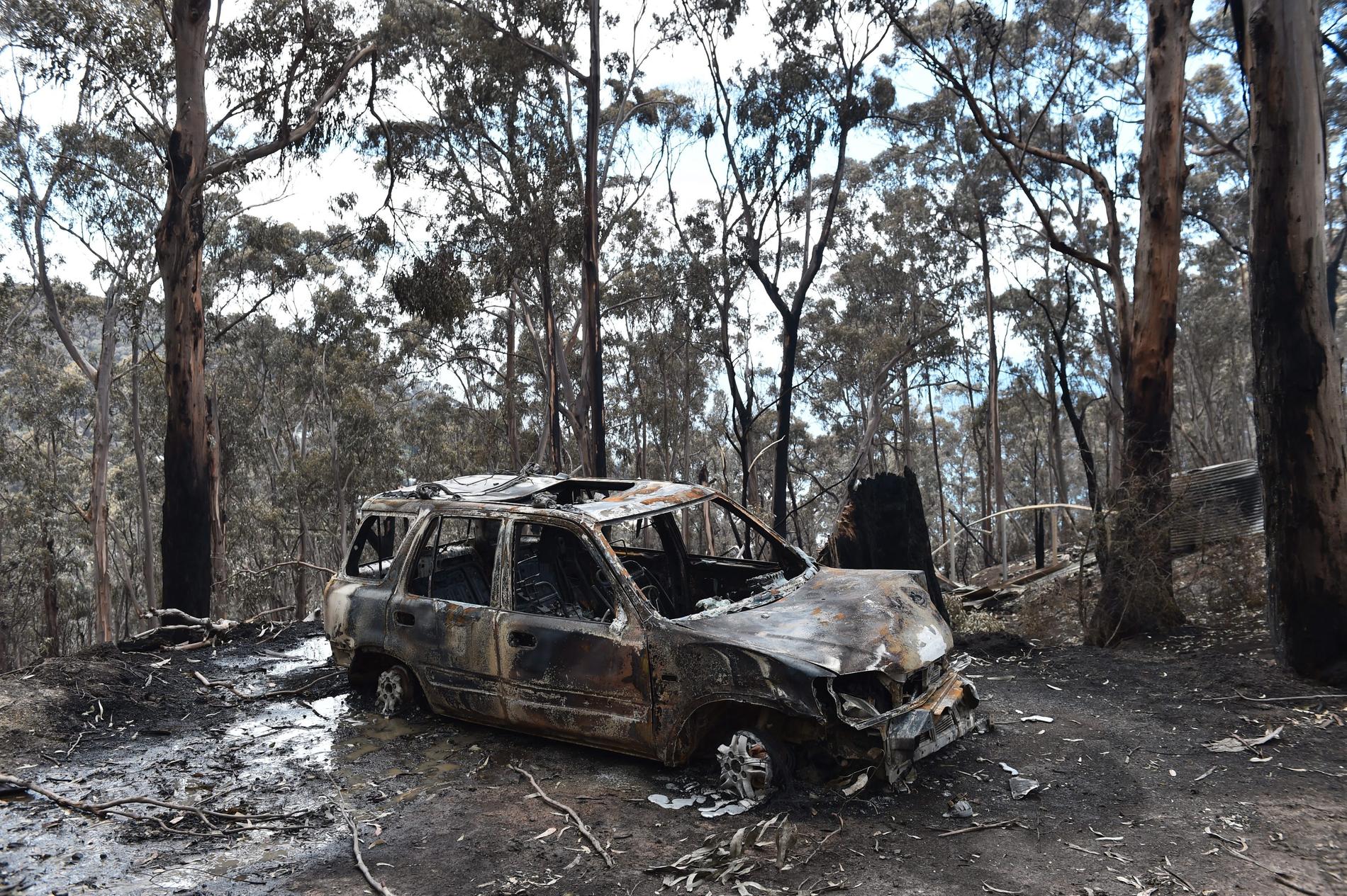 Ett utbränt bilvrak står kvar efter skogsbränder i Wye River, söder om Melbourne i Australien.