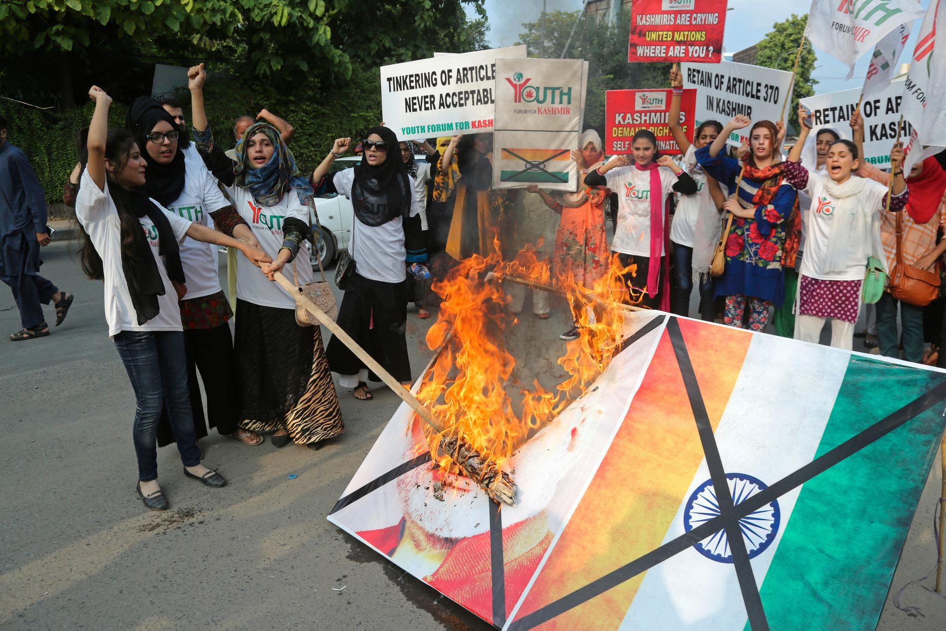 Pakistanska studenter i staden Lahore bränner en bild av Indiens premiärminister. Ilskan är stor över den indiska regeringens beslut att häva delar av delstaten Jammu och Kashmirs självstyre.