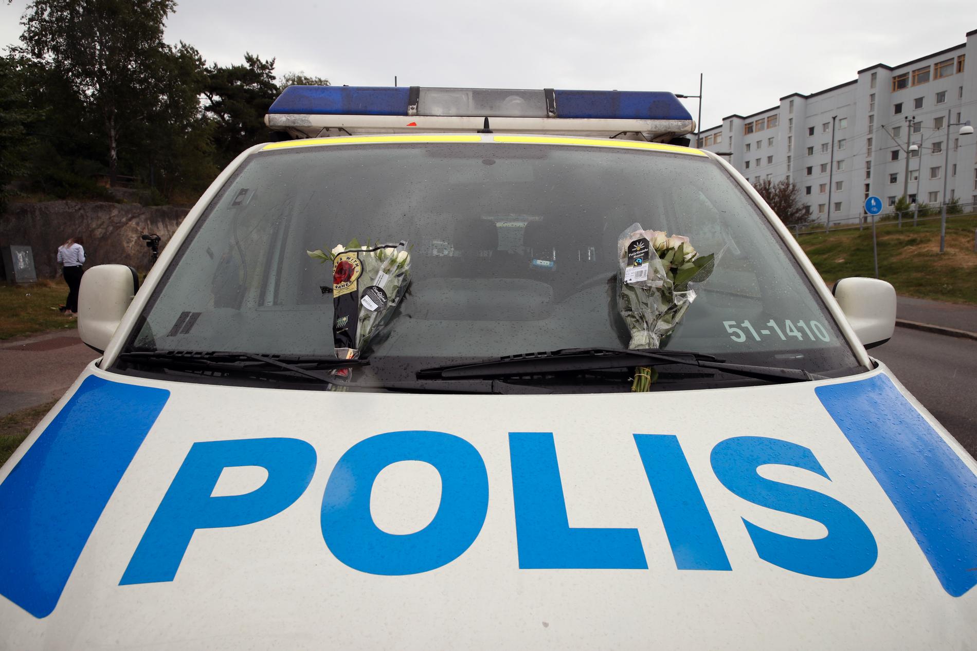 En polisbil med blommor i Biskopsgården.