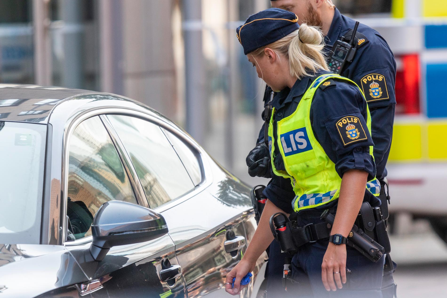 På bilden från den 29 augusti i fjol syns poliser som söker igenom en bil i Uppsala i samband med att en stor del av innerstaden spärrades av.