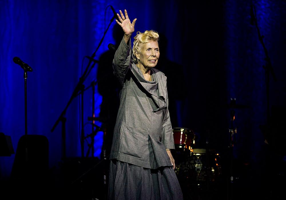 Joni Mitchell vinkar till publiken under jubileumskonserten när sångerskan fyllde 70.