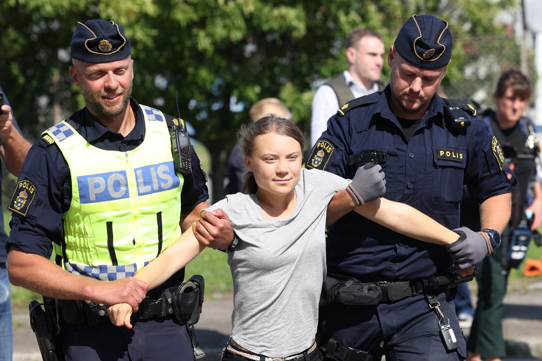 Greta Thunberg lyfts iväg av två polisen under klimataktionen i Malmö. 