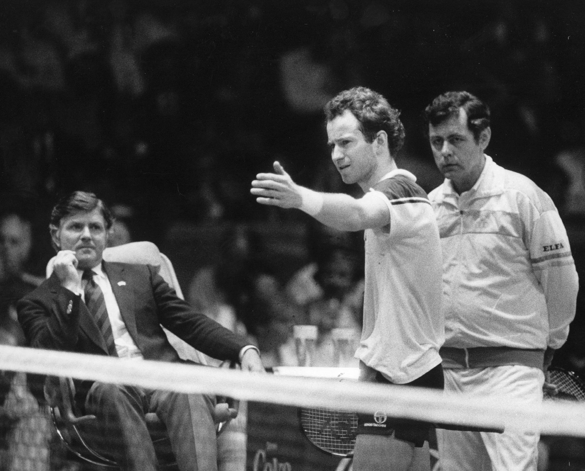 John McEnroe i diskussion med domaren under Davis Cup-finalen 1984. Sveriges förbundskapten Hans Olsson till höger.