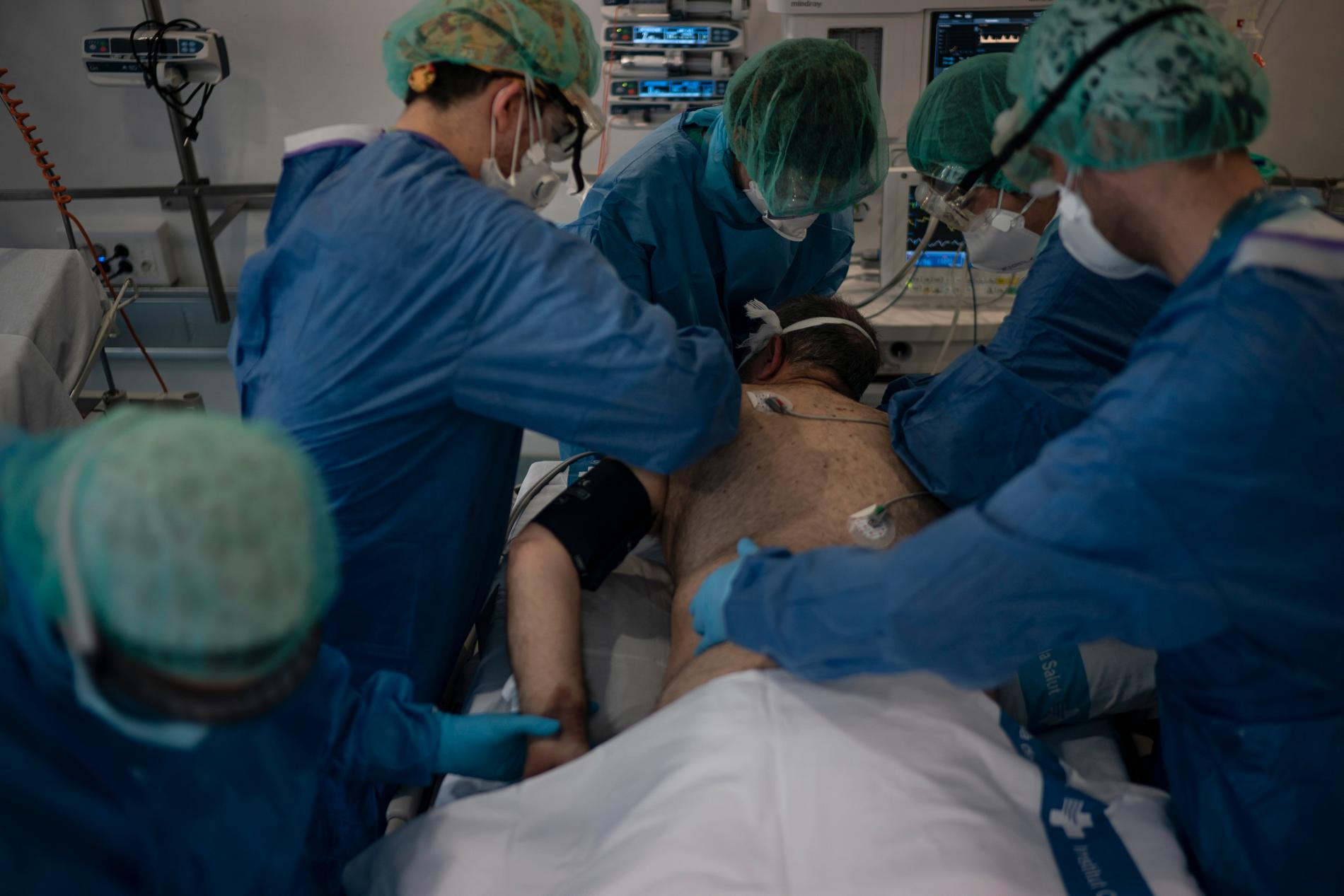Vårdpersonal tar hand om en covid-19-patient på ett bibliotek som gjorts om till tillfälligt sjukhus i Barcelona, Spanien.