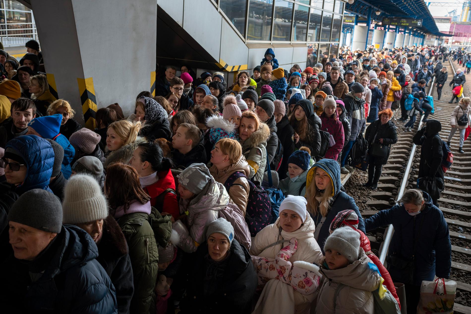 Människor trängs för att komma med tågen på Kievs centralstation.