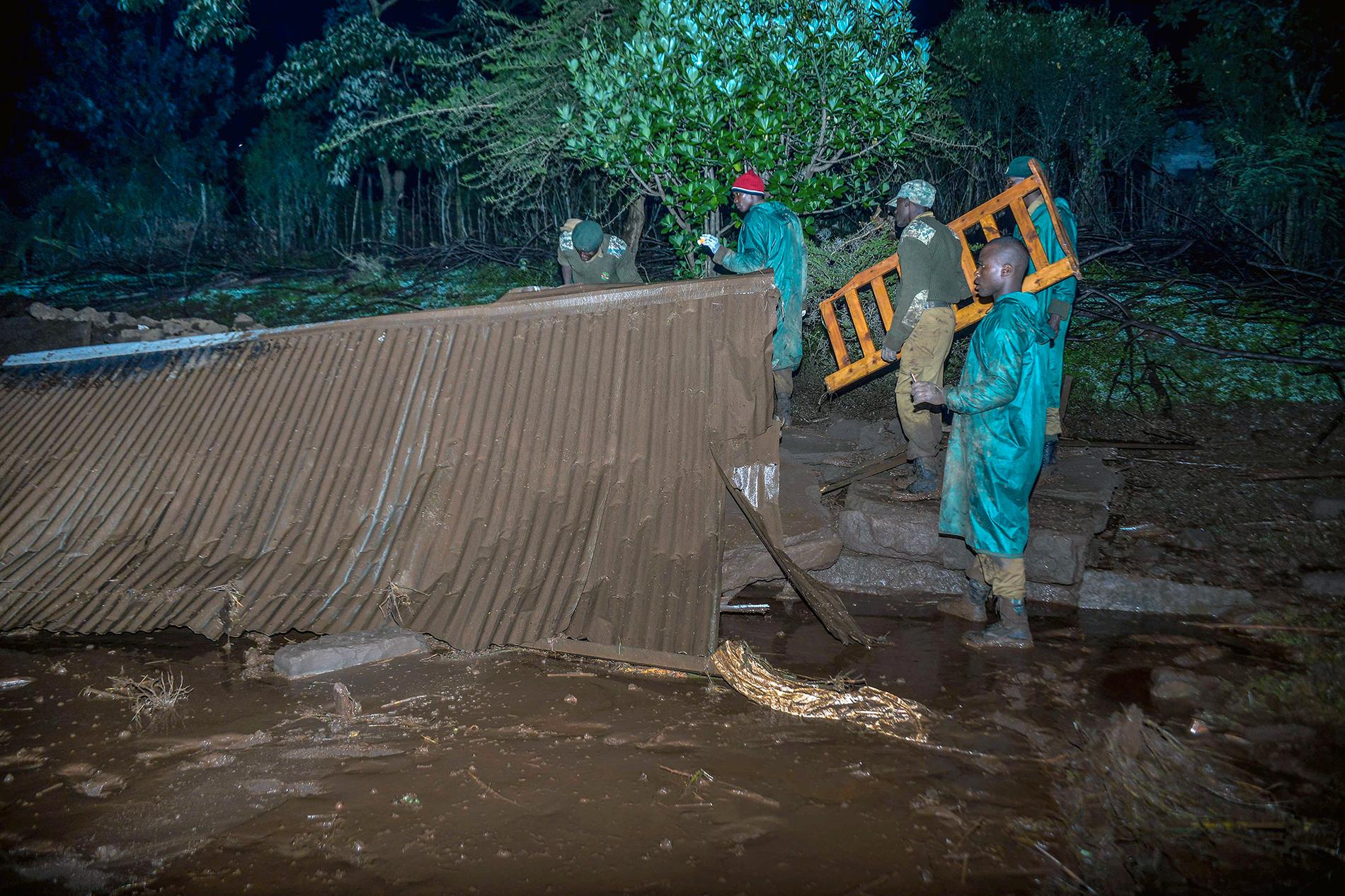 Räddningsarbetare söker igenom ett boende efter att en damm brustit i Nakaru provinsen i Kenya. 