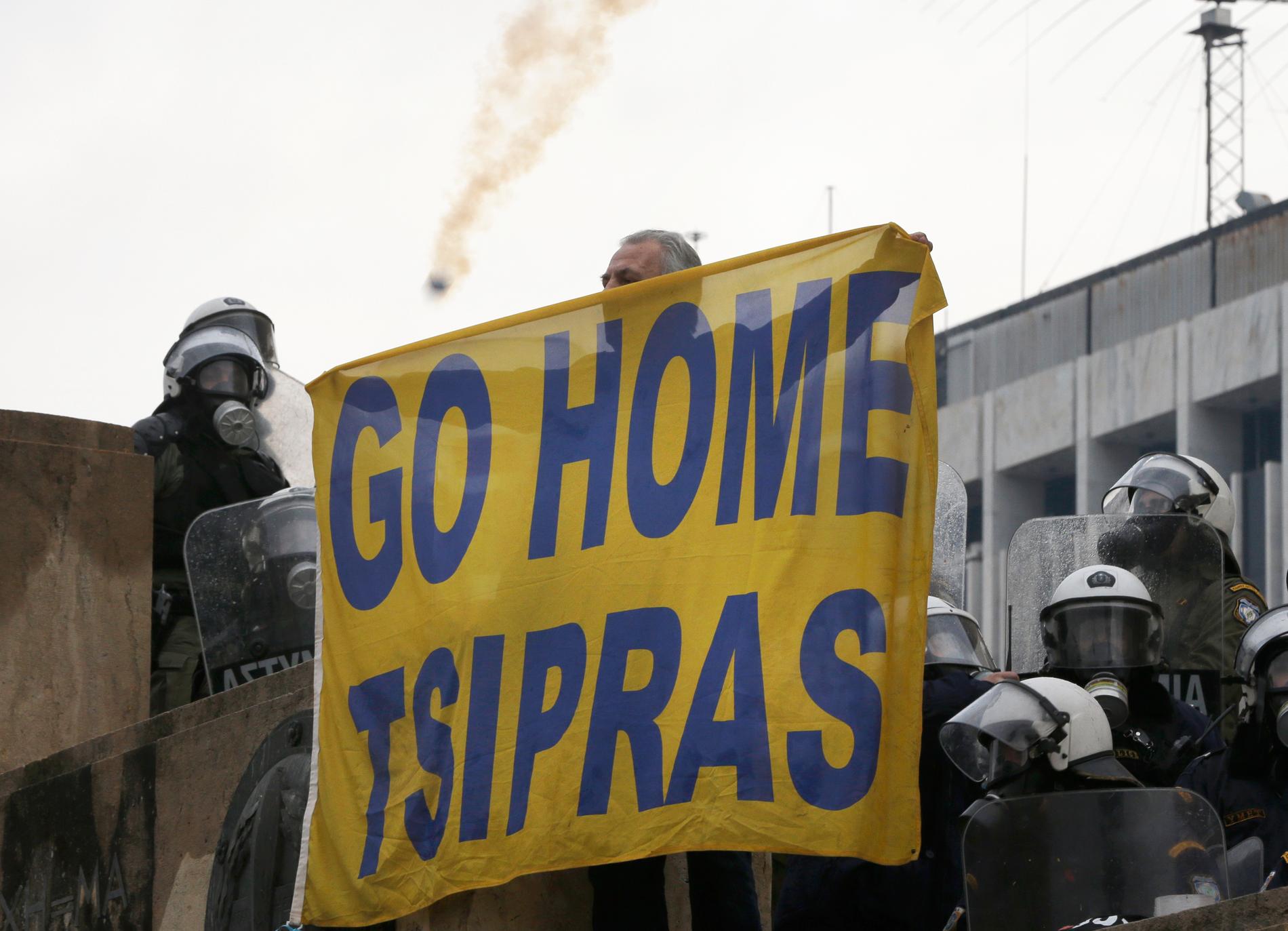 En demonstrant håller upp en banderoll i protest mot Greklands premiärminister Alexis Tsipras under den stora demonstrationen mot Makedoniens namnbyte i Aten i söndags.