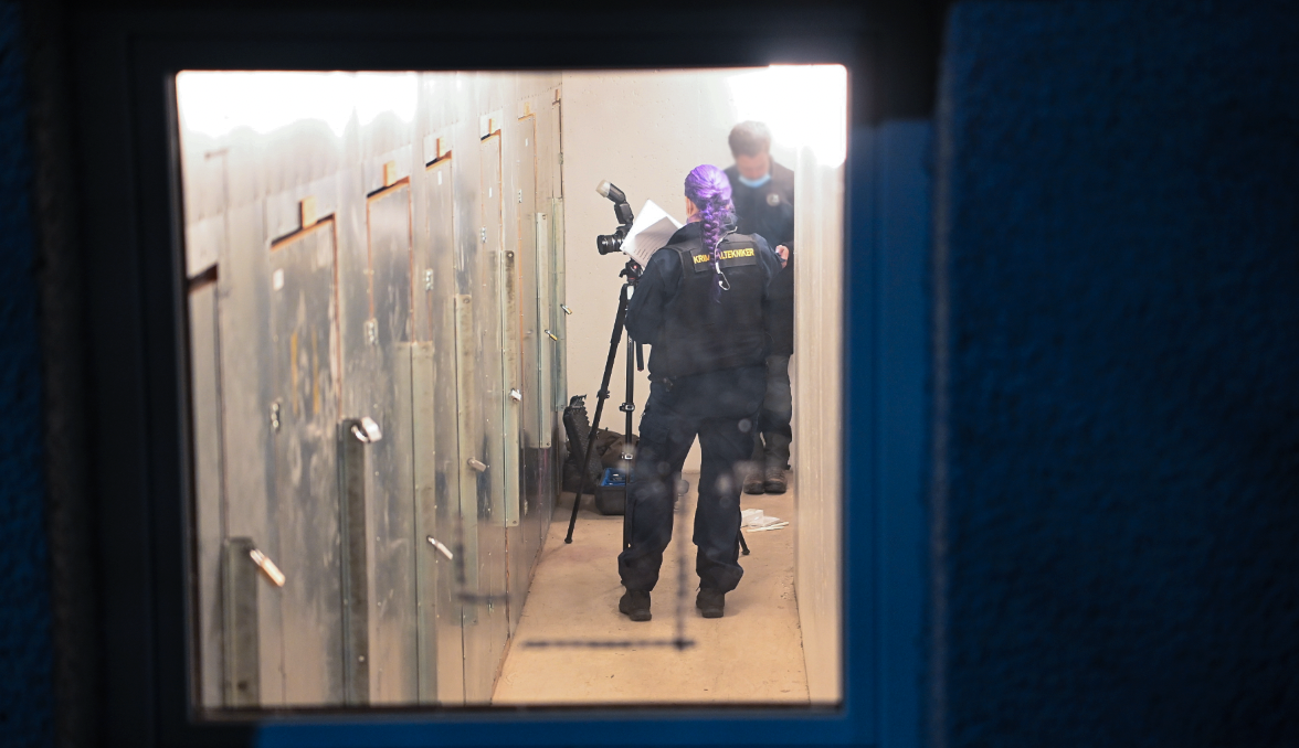 Polisens tekniker undersöker ett källarförråd i huset i Skogås söder om Stockholm mycket noga. 