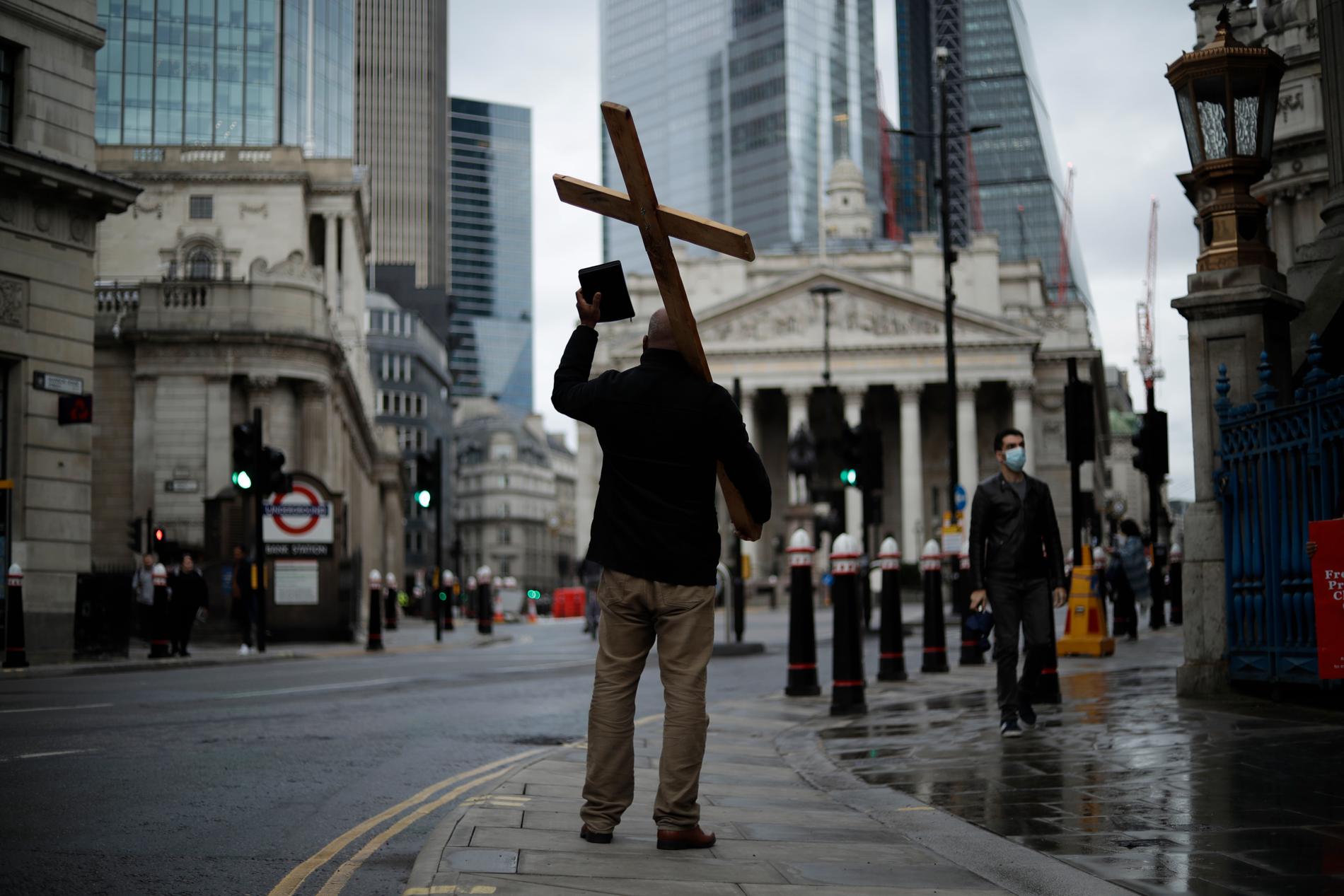 En man med ett stort kors predikar på egen hand i centrala London. Arkivbild från november 2020.