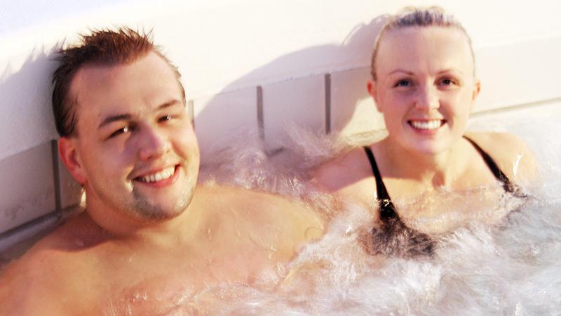 Helga och Heimir njuter i en av Árbæjarlaugs pooler.